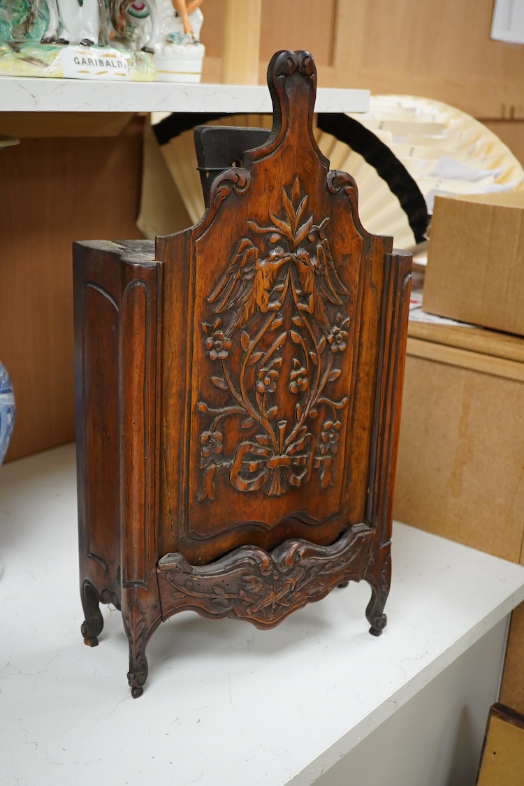 An 18th century French walnut candle box, modelled as a miniature armoire, carved with birds and flowers, 50cm high